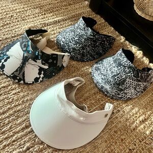 Four Lululemon visors in various patterns